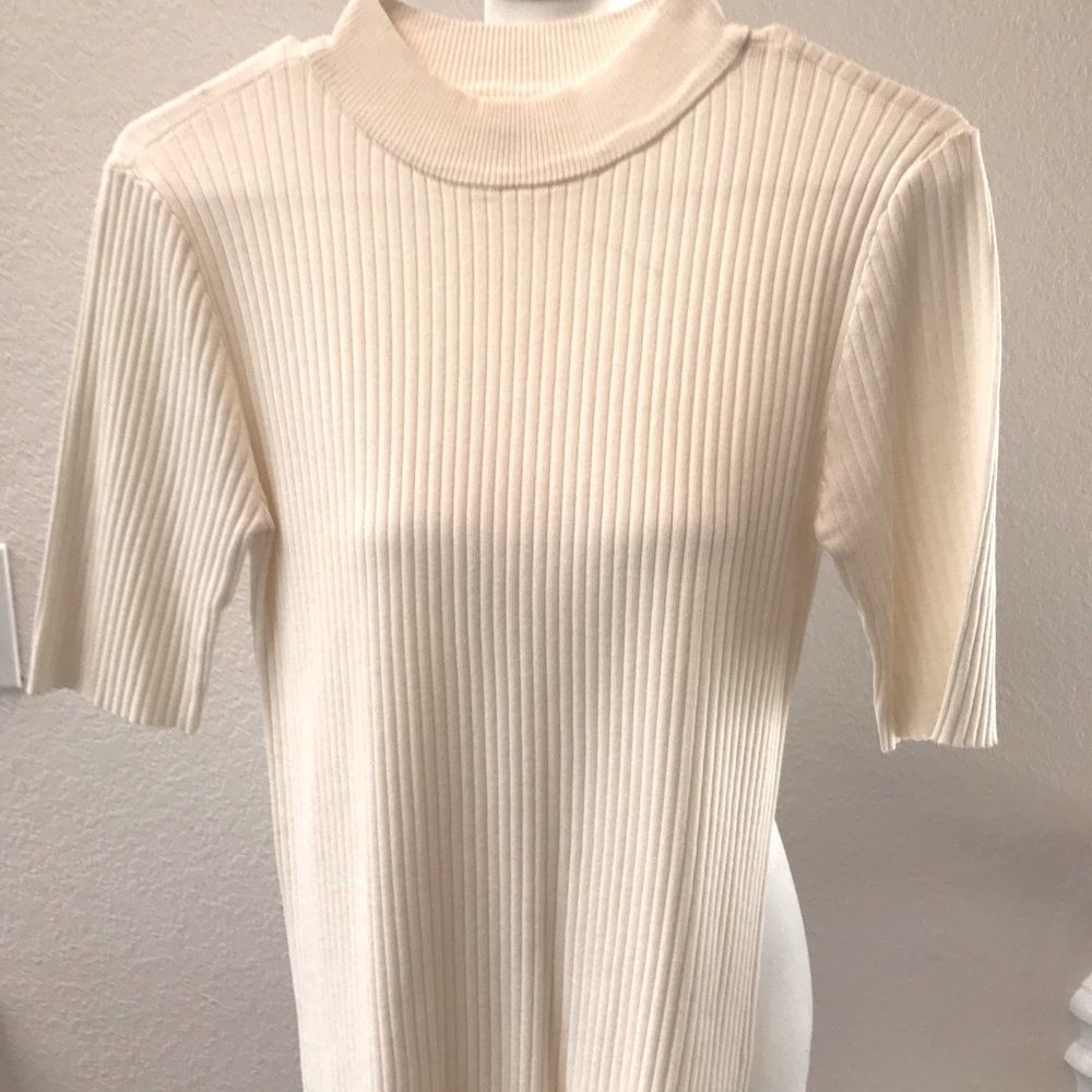 ELBOW LENTH SLEEVES ON THIS OFF WHITE SWEATER.